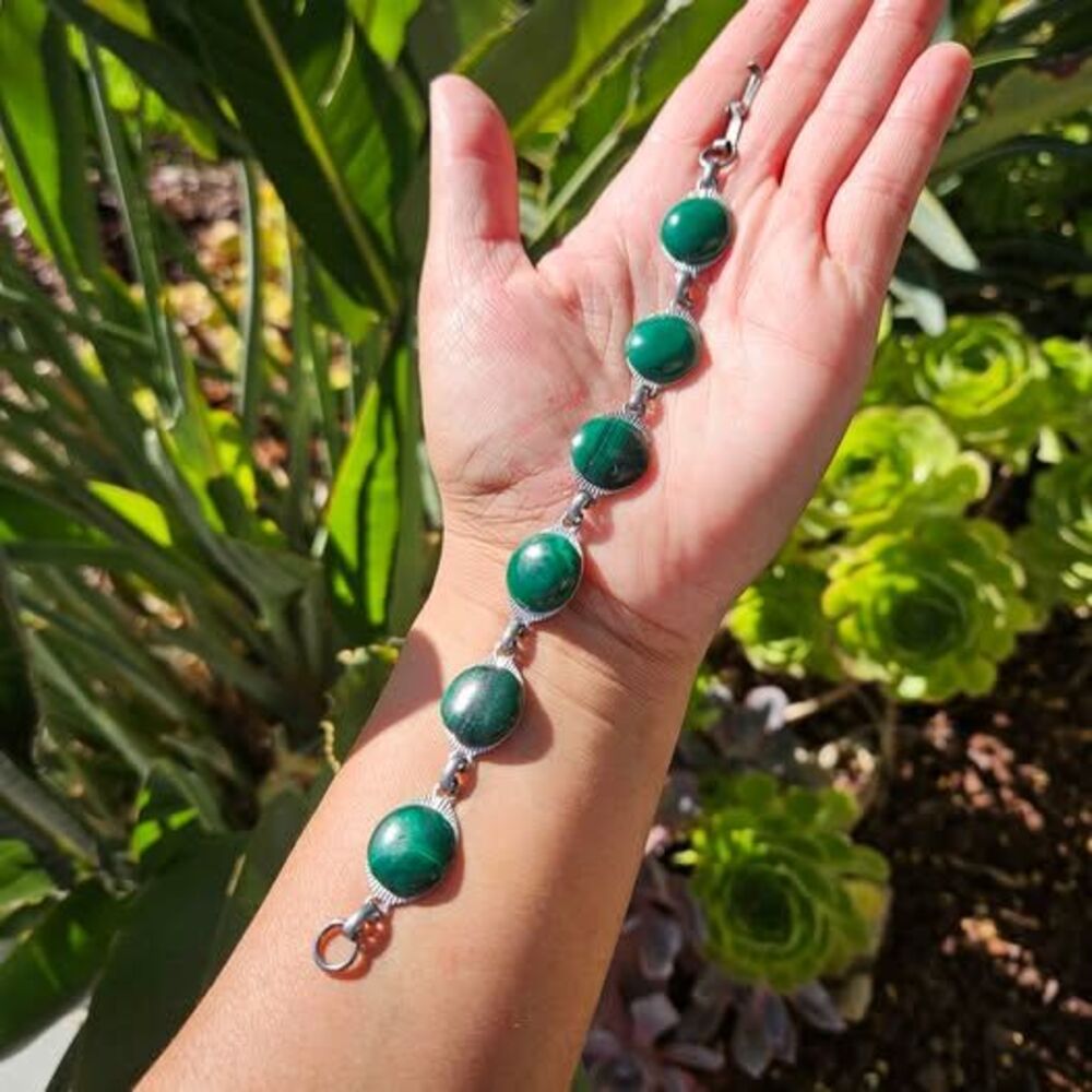 Malachite bracelet features natural green gemstones set in a silver colored link